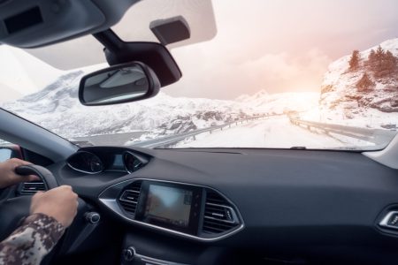 Hand holding steering wheel in luxury private car, Driving in rural road on winter season